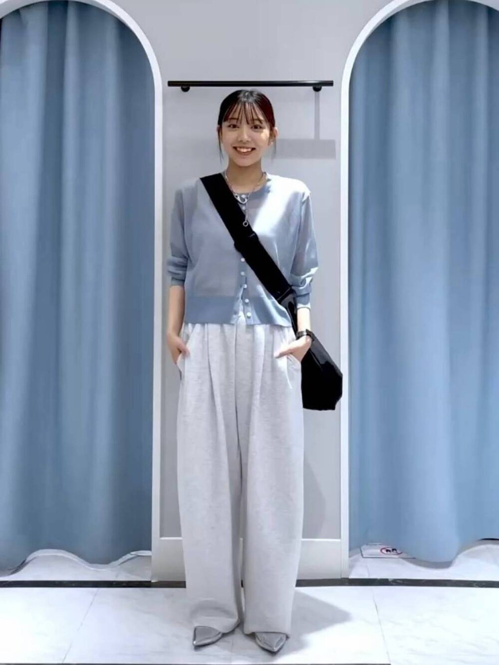 ブラック系のショルダーバッグ、ブラック系のパンプス、グレー系のスウェットパンツを着用したレディースの春コーディネートの1枚目の写真