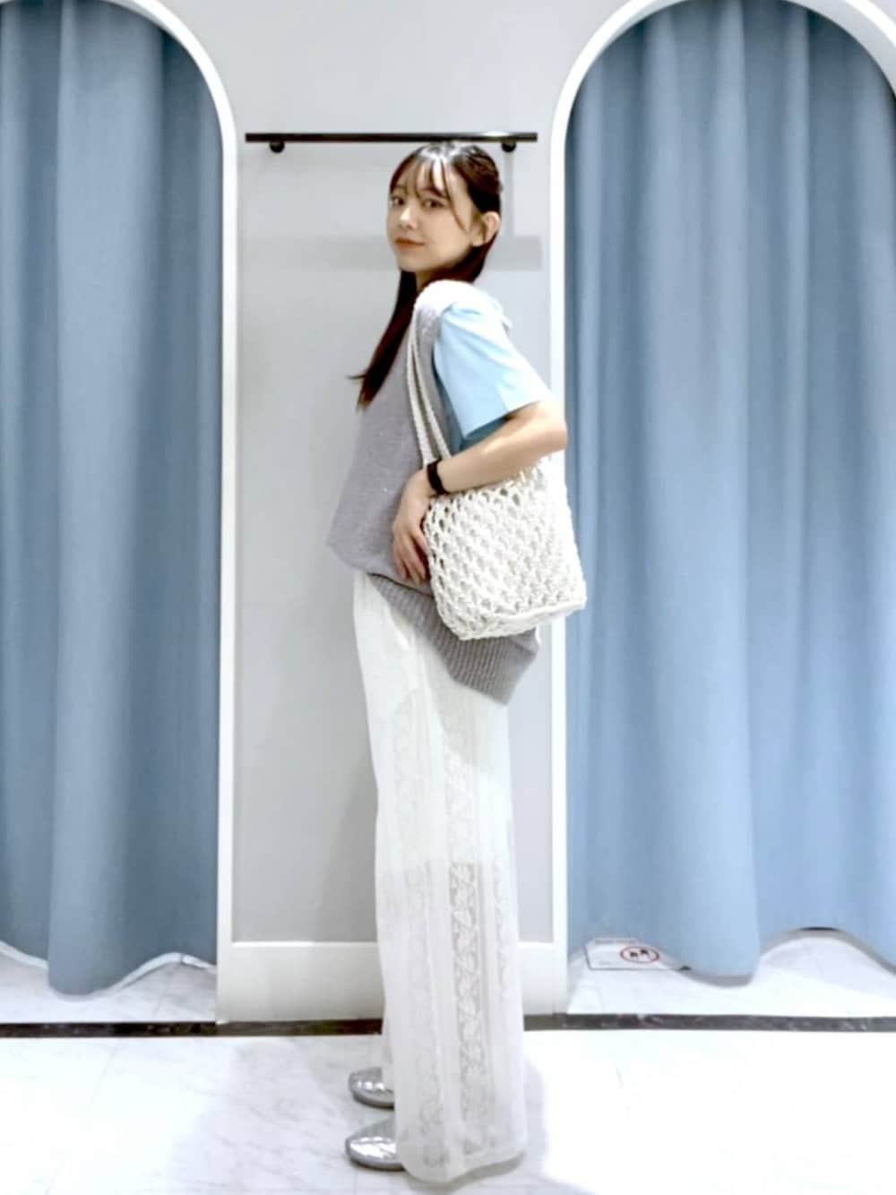 ホワイト系のトートバッグ、シルバー系のスニーカー、ブルー系のTシャツ/カットソーを着用したレディースの春コーディネートの1枚目の写真