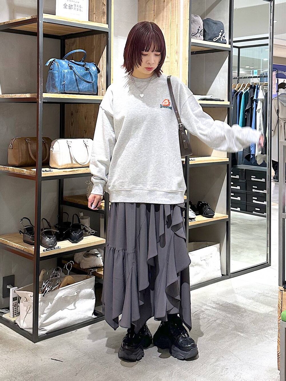 ブラック系のスニーカー、グレー系のスカート、グレー系のスウェットを着用したレディースの春コーディネートの1枚目の写真