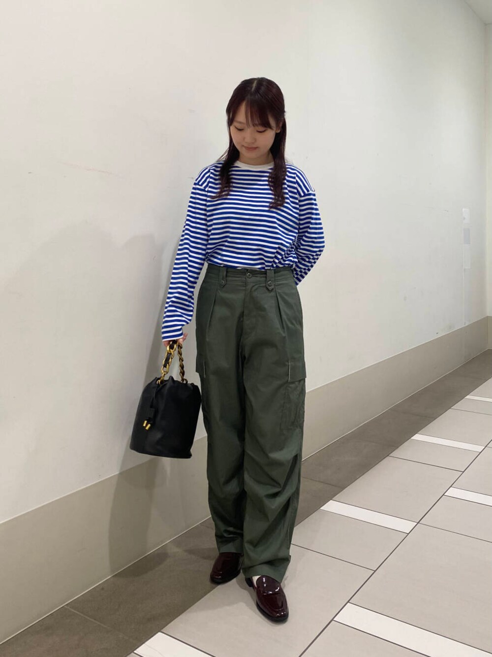 グリーン系のカーゴパンツ、ブラック系のショルダーバッグ、レッド系のローファーを着用したレディースの夏コーディネートの1枚目の写真