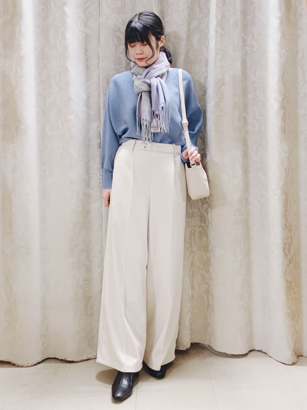 ブルー系のニット/セーター、ベージュ系のその他パンツ、ブラック系のブーツを着用したレディースの冬コーディネートの1枚目の写真