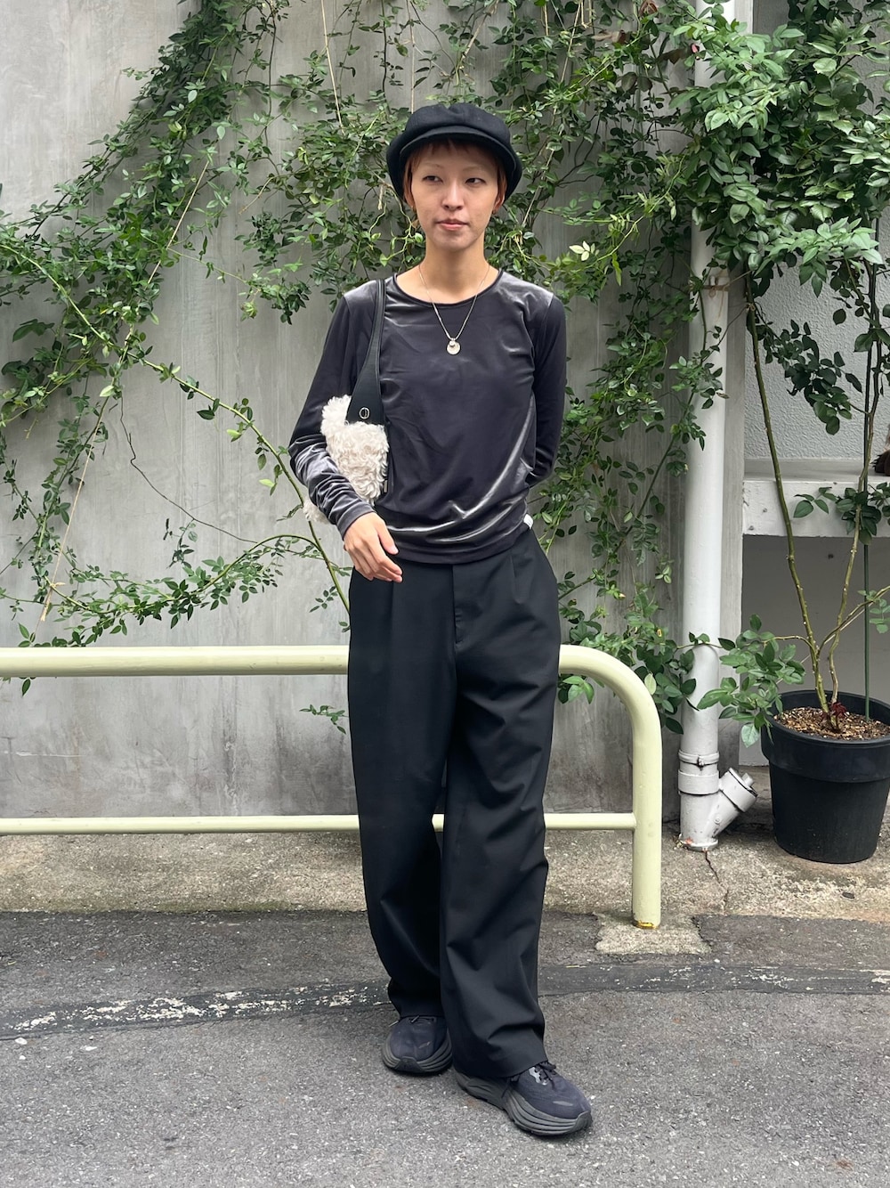ブラック系のスラックス、グレー系のTシャツ/カットソー、ベージュ系のハンドバッグを着用したレディースの秋コーディネートの1枚目の写真