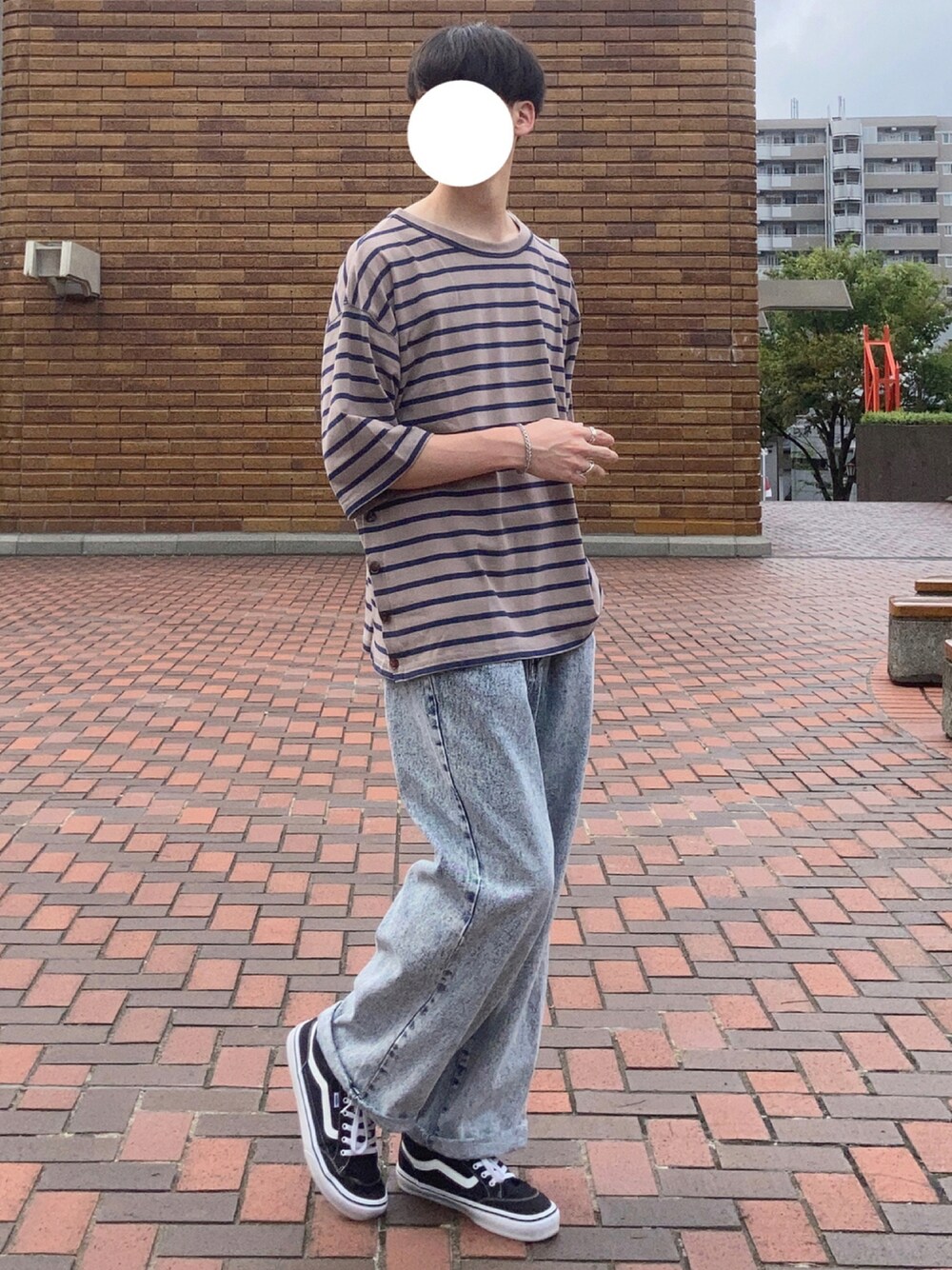 ベージュ系のTシャツ/カットソー、ブルー系のデニムパンツ、ブラック系のスニーカーを着用したメンズの夏コーディネートの1枚目の写真