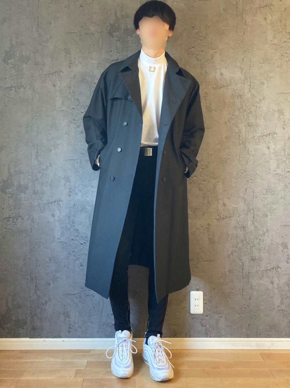 ホワイト系のTシャツ/カットソー、グレー系のトレンチコート、ブラック系のデニムパンツを着用したメンズの秋コーディネートの1枚目の写真