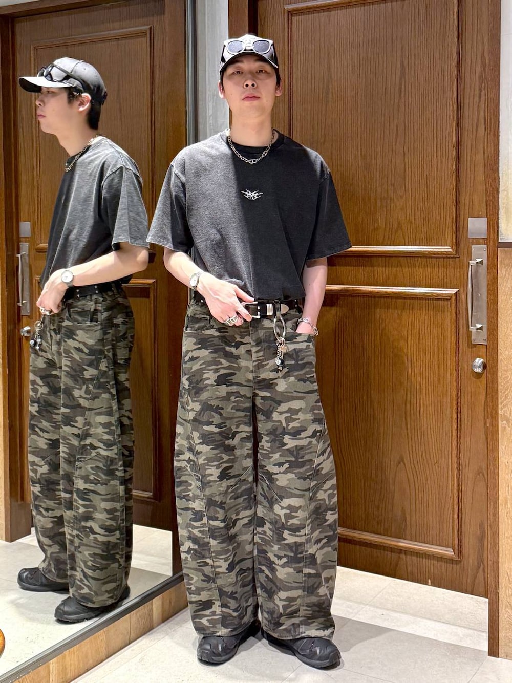 グリーン系のデニムパンツ、ブラック系のTシャツ/カットソー、ブラック系のキーホルダーを着用したメンズの春コーディネートの1枚目の写真