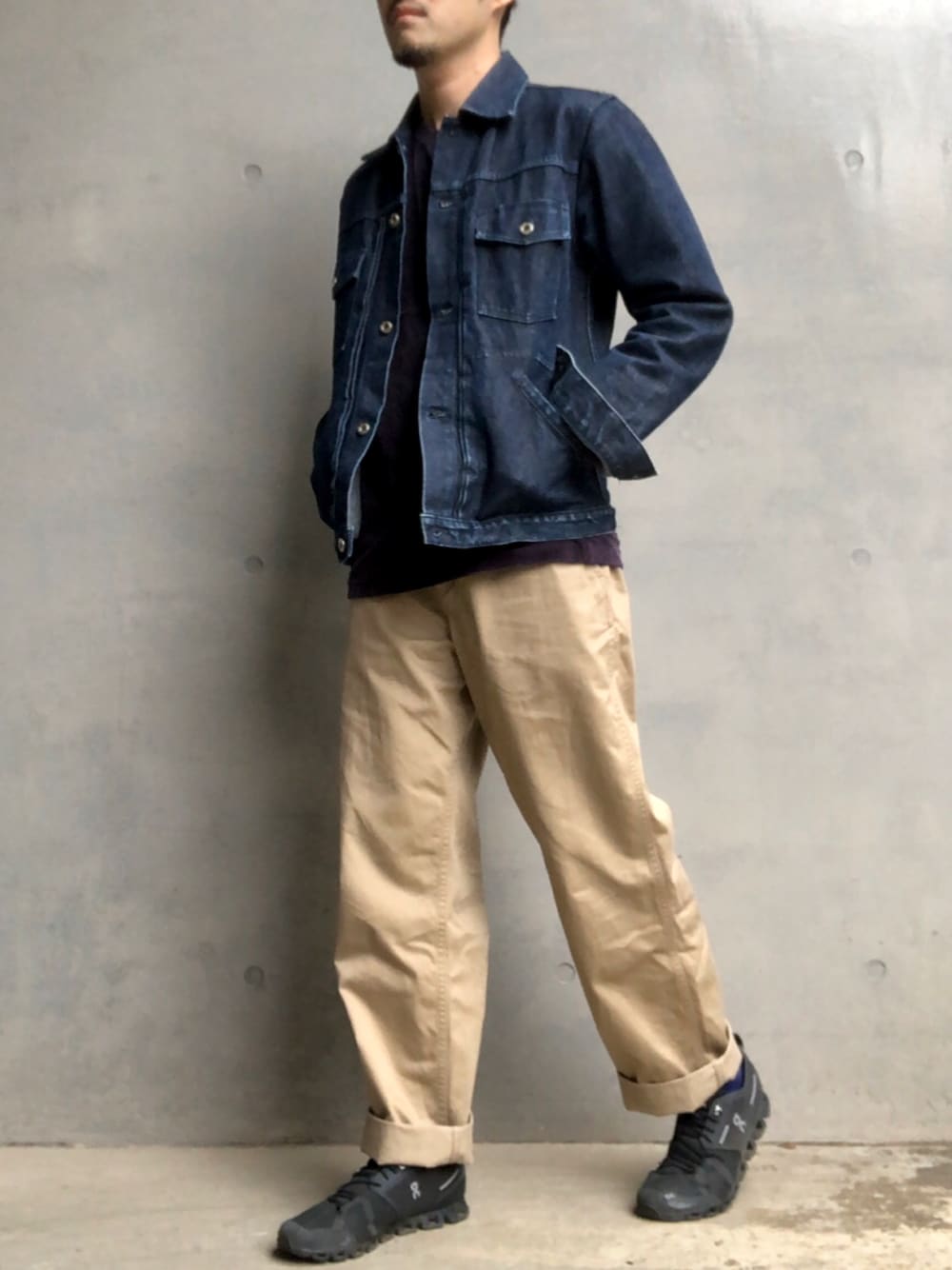 ブルー系のデニムジャケット、ブラック系のチノパンツ、ブラック系のスニーカーを着用したメンズの春コーディネートの1枚目の写真