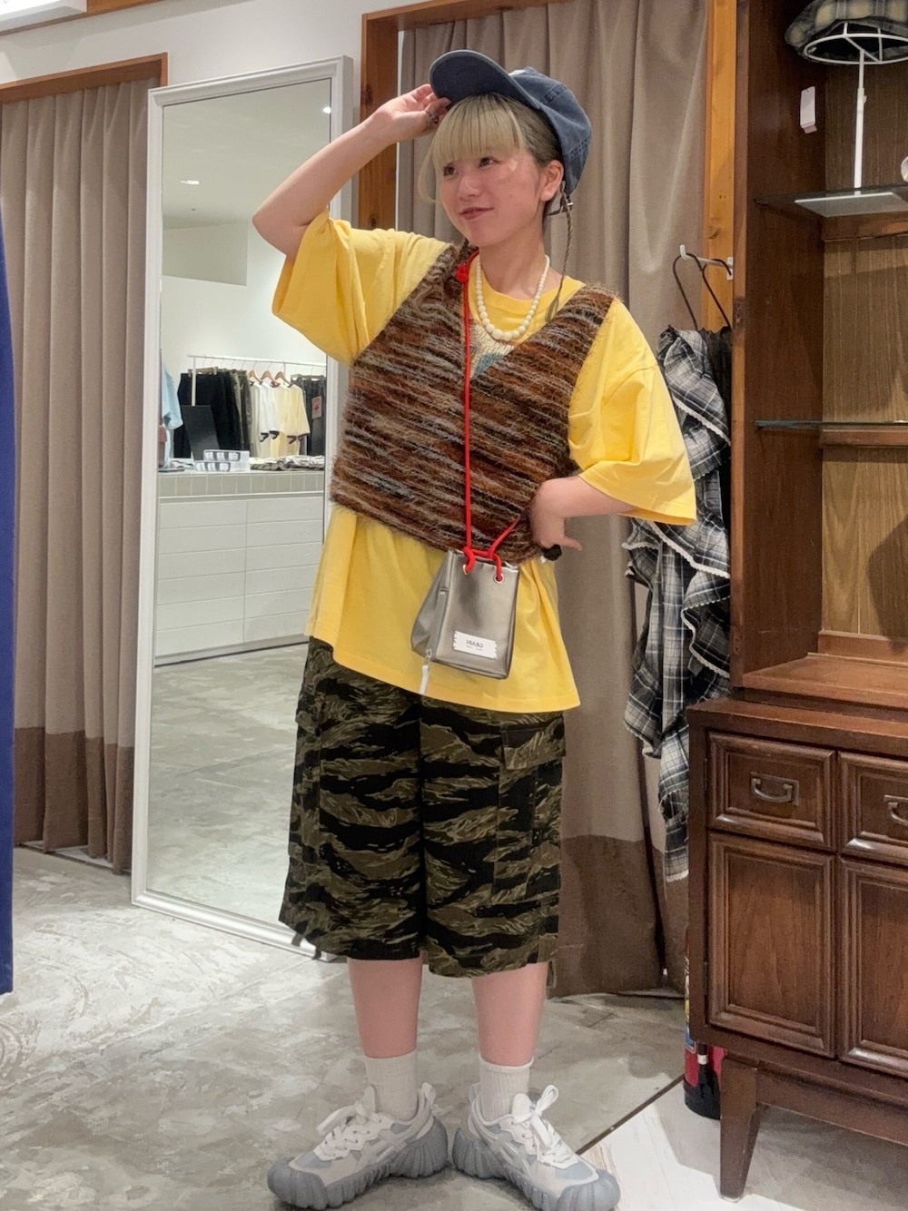 その他のショルダーバッグ、グリーン系のその他パンツ、オレンジ系のベストを着用したレディースの秋コーディネートの1枚目の写真