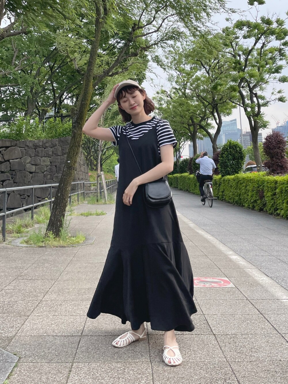 ブラック系のTシャツ/カットソー、ブラック系のワンピース、ホワイト系のサンダルを着用したレディースの春コーディネートの1枚目の写真