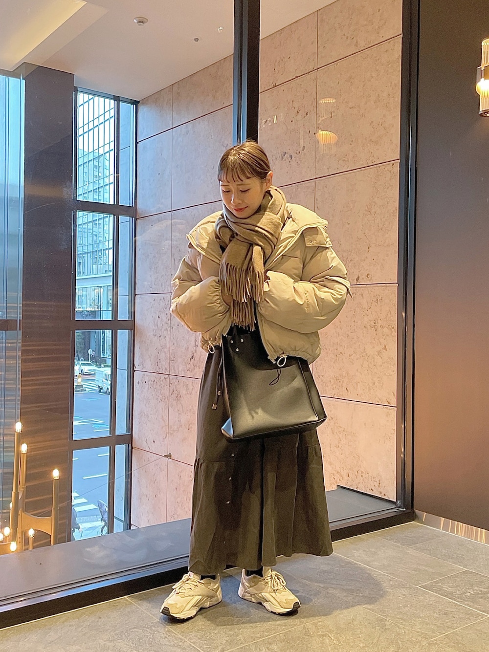 ホワイト系のダウンジャケット/コート、ブラック系のトートバッグ、グレー系のシャツワンピースを着用したレディースの冬コーディネートの1枚目の写真