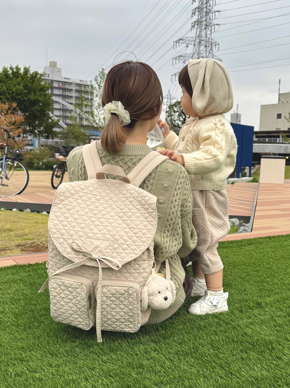 ホワイト系のスニーカー、ホワイト系のバックパック/リュック、ホワイト系のその他ベビーウェアを着用したレディースの秋コーディネートの1枚目の写真