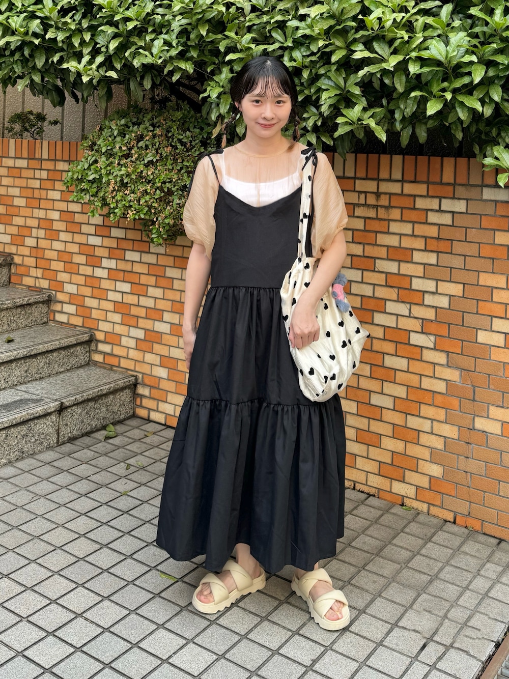 オレンジ系のシャツ/ブラウス、ブラック系のワンピース、その他のトートバッグを着用したレディースの春コーディネートの1枚目の写真