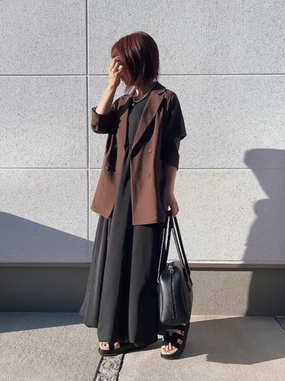 ブラウン系のジャケット/アウター、ブラック系のワンピース/ドレス、ブラック系のバッグを着用したレディースの秋コーディネートの1枚目の写真