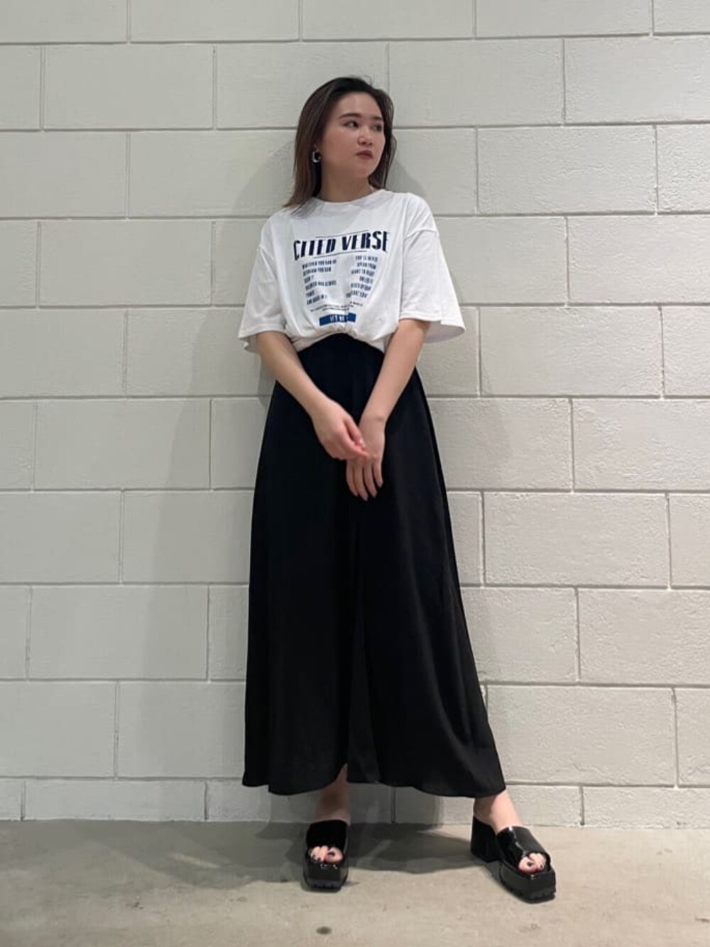 ブラック系のサンダル、ブラック系のワンピース、ホワイト系のTシャツ/カットソーを着用したレディースの春コーディネートの1枚目の写真