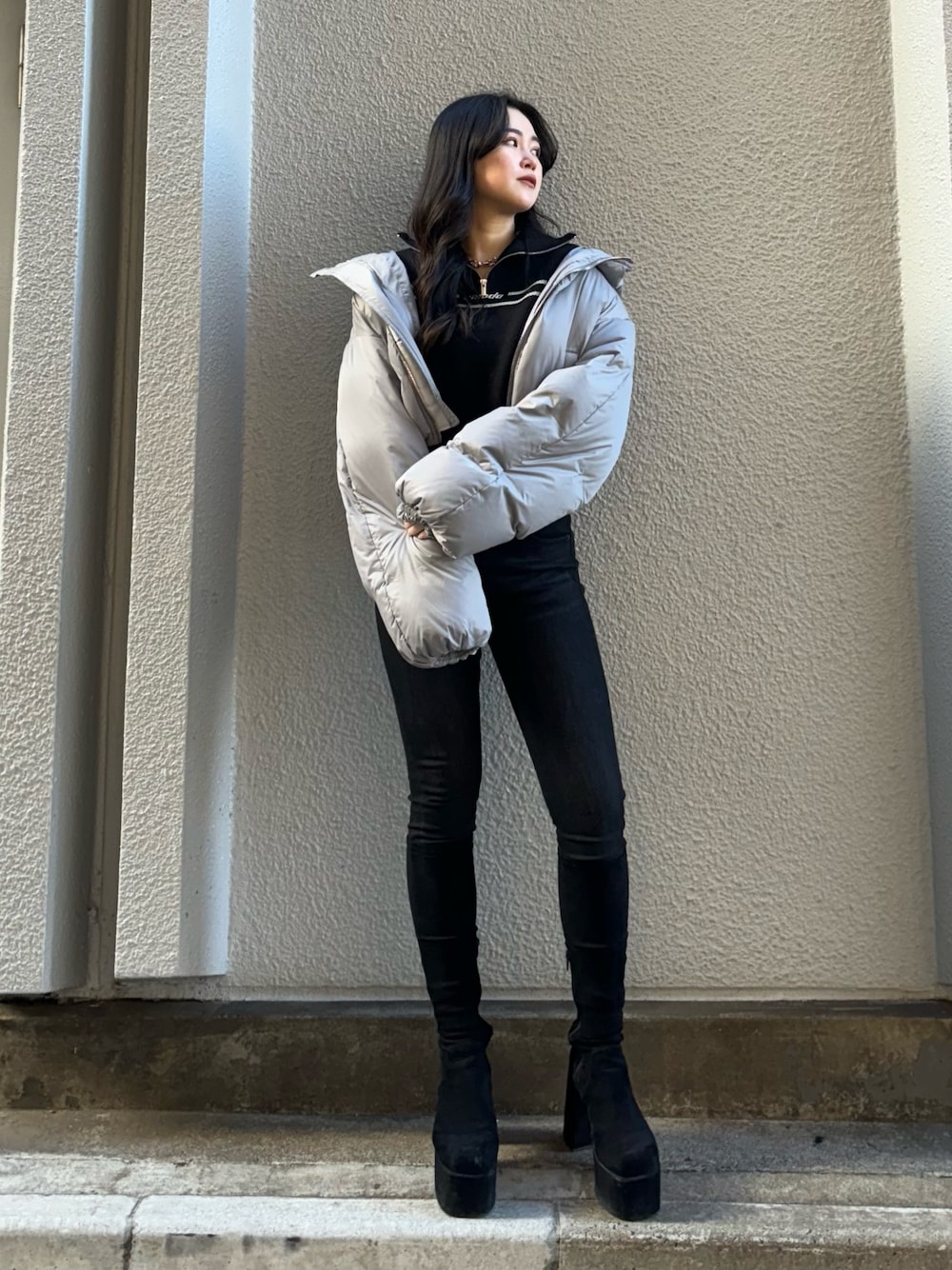 ブルー系のニット/セーター、グレー系のダウンジャケット/コート、ブラック系のデニムパンツを着用したレディースの冬コーディネートの1枚目の写真