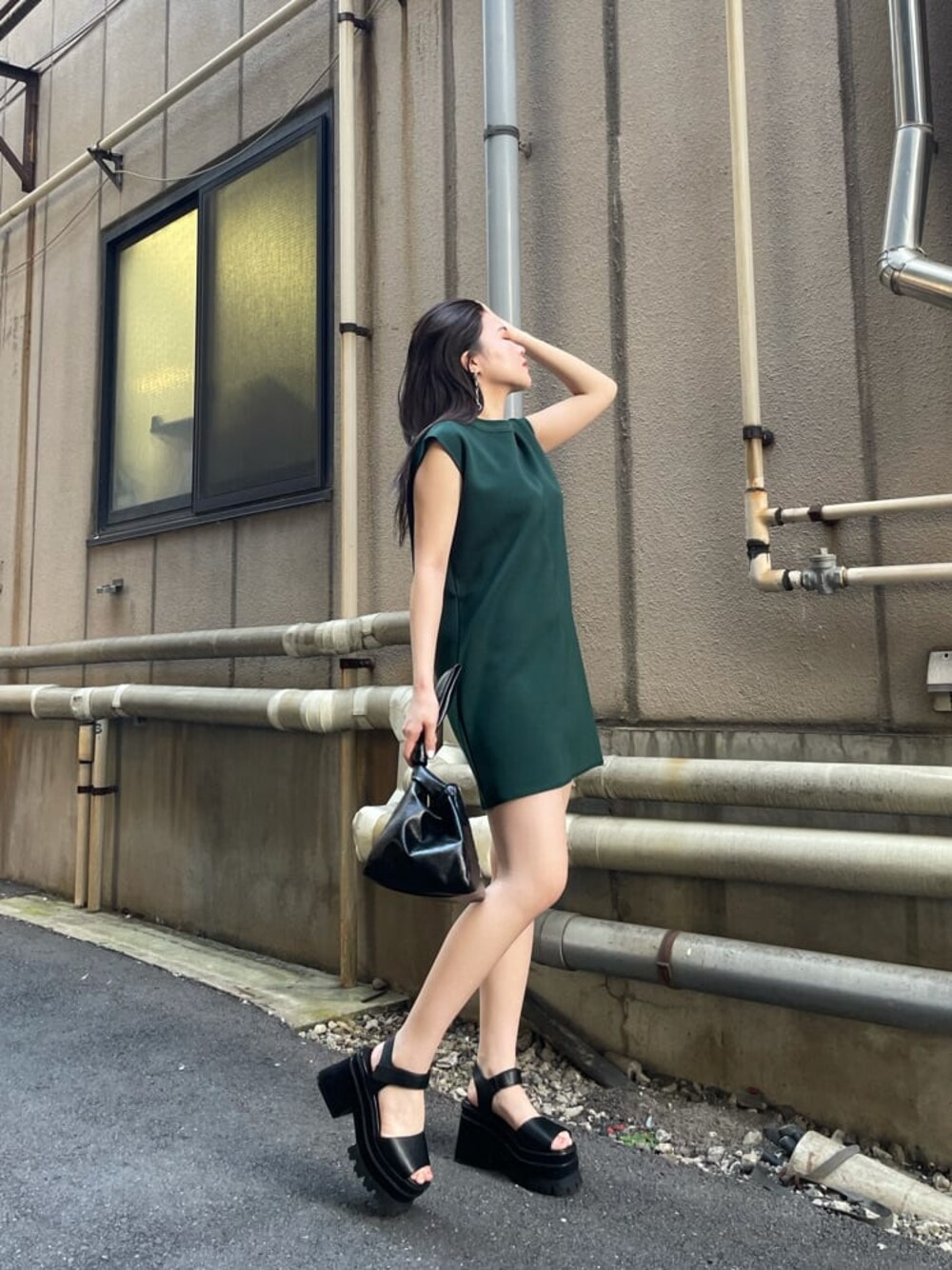 グリーン系のワンピース、ブラック系のハンドバッグを着用したレディースの夏コーディネートの1枚目の写真