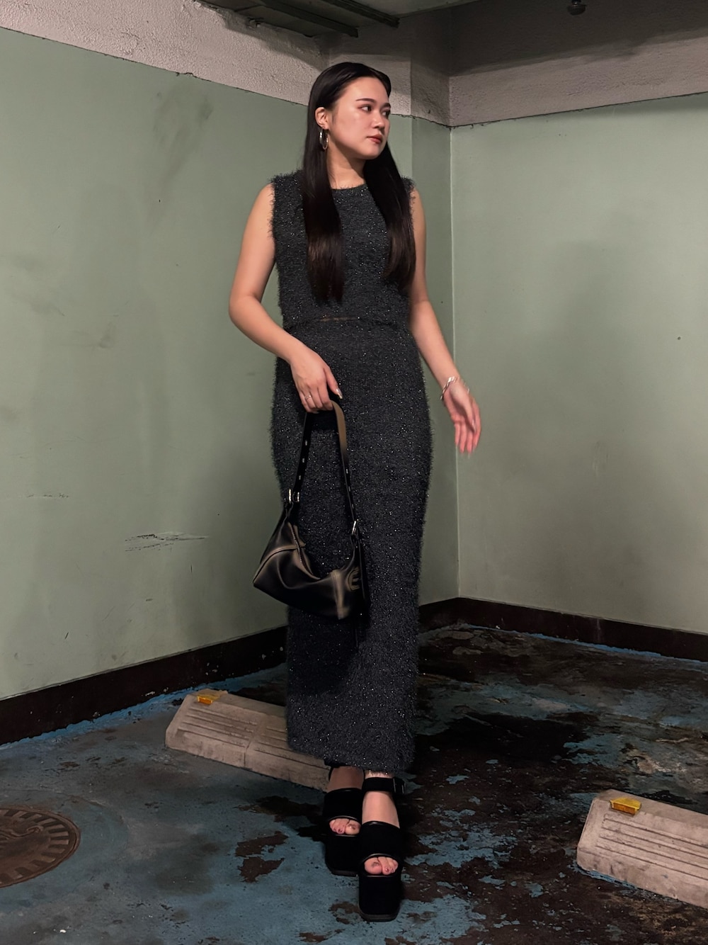 ブラック系のサンダル、ブラック系のハンドバッグ、グレー系のタンクトップを着用したレディースの夏コーディネートの1枚目の写真