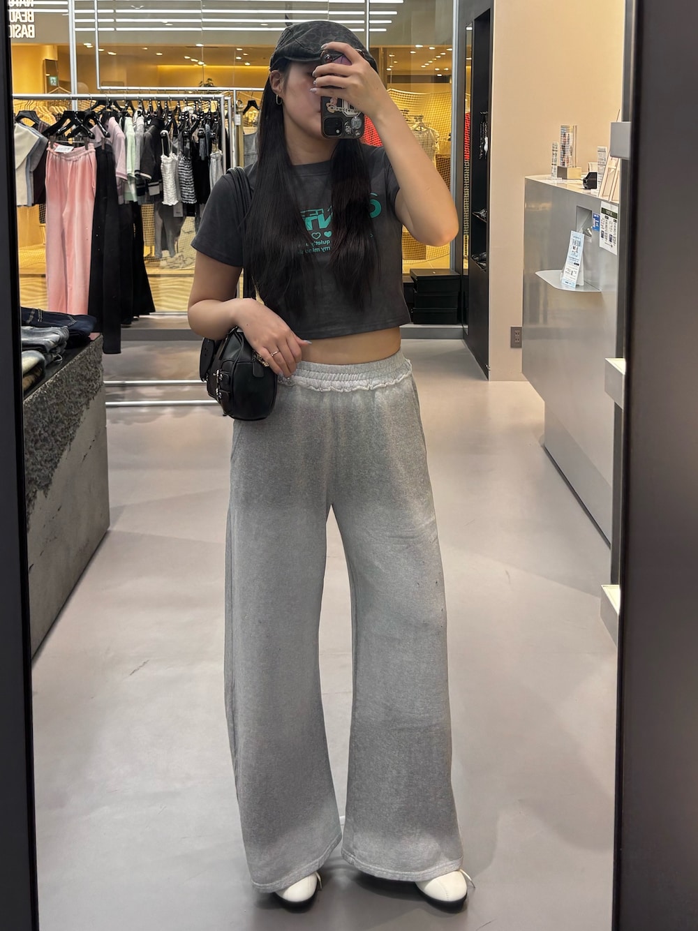 グレー系のTシャツ/カットソー、ホワイト系のハンドバッグ、グレー系のスウェットパンツを着用したレディースの春コーディネートの1枚目の写真