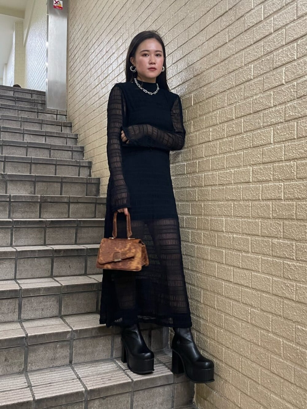 ブラック系のブーツ、ブラック系のワンピース、シルバー系のネックレスを着用したレディースの秋コーディネートの1枚目の写真