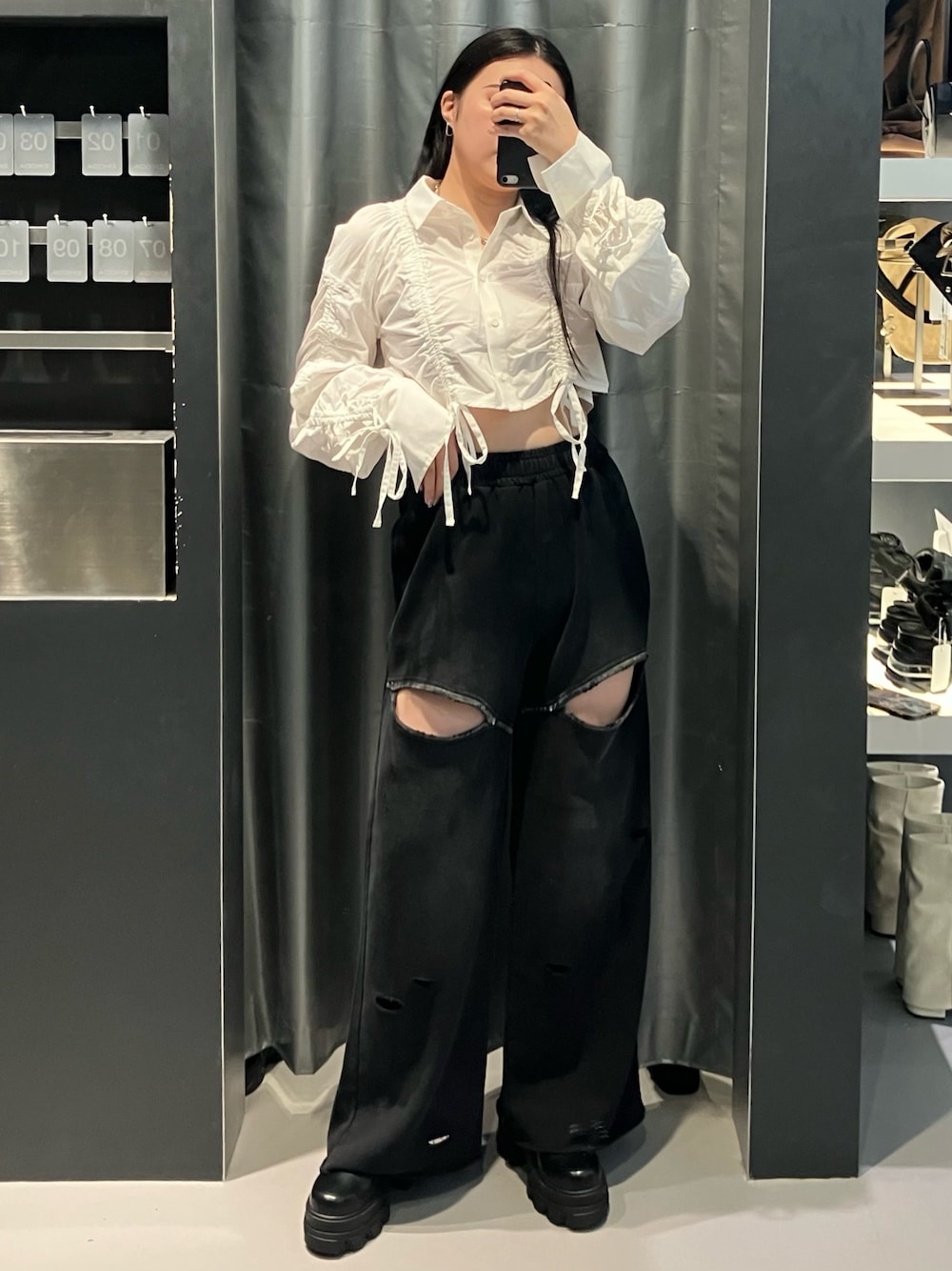 ブラック系のスウェットパンツ、ホワイト系のシャツ/ブラウス、ブラウン系のブーツを着用したレディースの秋コーディネートの1枚目の写真