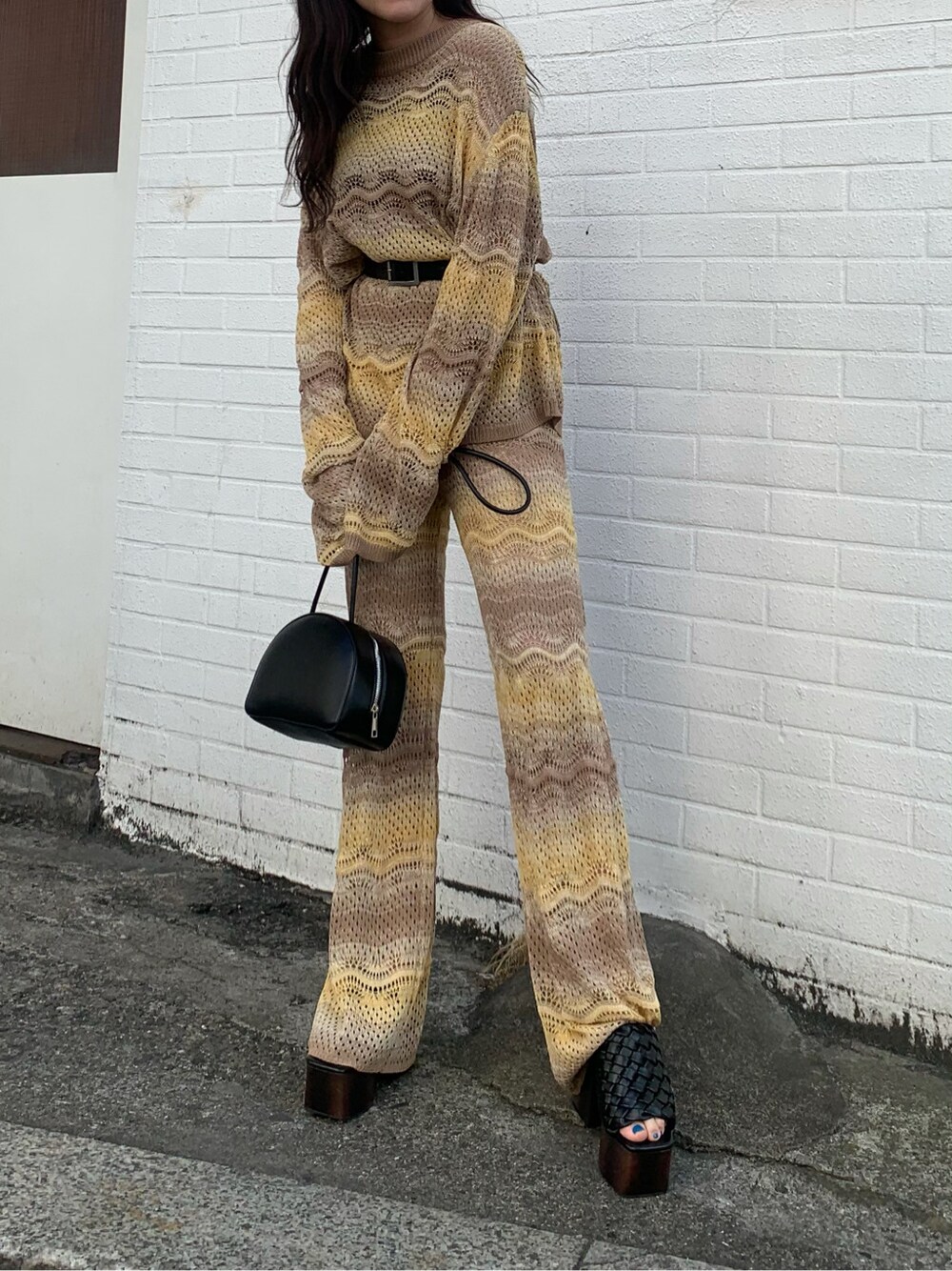 ベージュ系のその他パンツ、ブラック系のサンダル、ベージュ系のニット/セーターを着用したレディースの春コーディネートの1枚目の写真