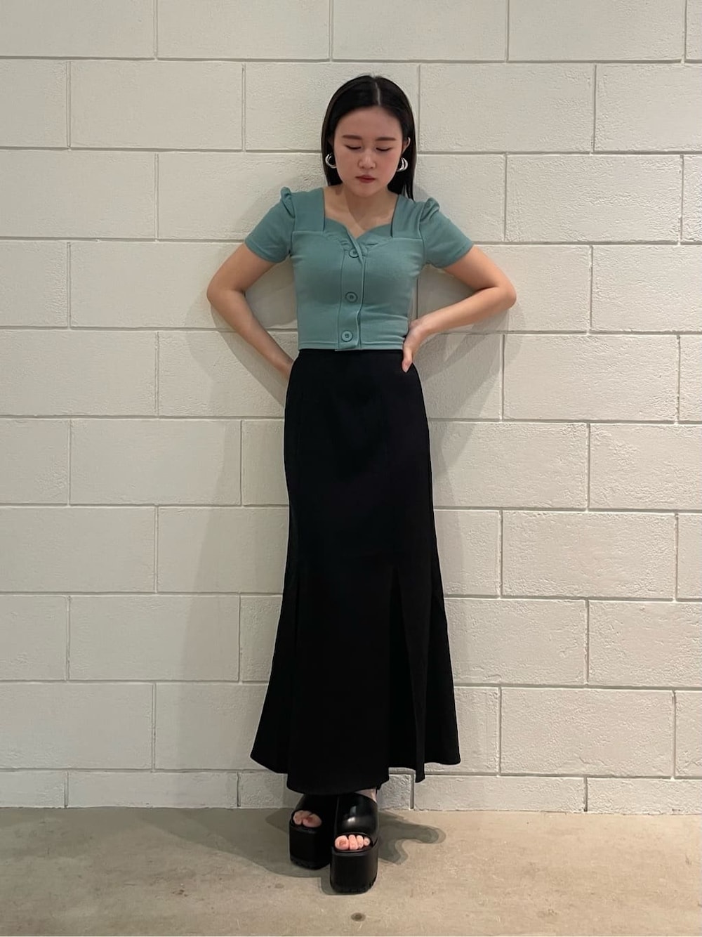ブラック系のスカート、ブラック系のサンダル、ブルー系のTシャツ/カットソーを着用したレディースの夏コーディネートの1枚目の写真