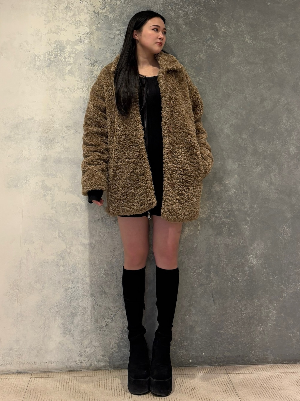 ブラック系のブーツ、ベージュ系のその他アウター、グレー系のワンピースを着用したレディースの冬コーディネートの1枚目の写真