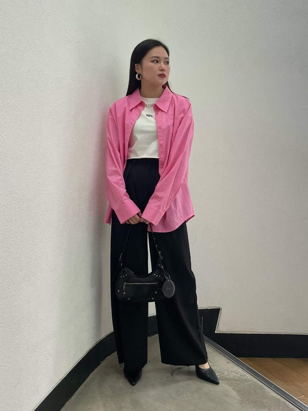 ブラック系のパンプス、ブラック系のハンドバッグ、ピンク系のシャツ/ブラウスを着用したレディースの冬コーディネートの1枚目の写真