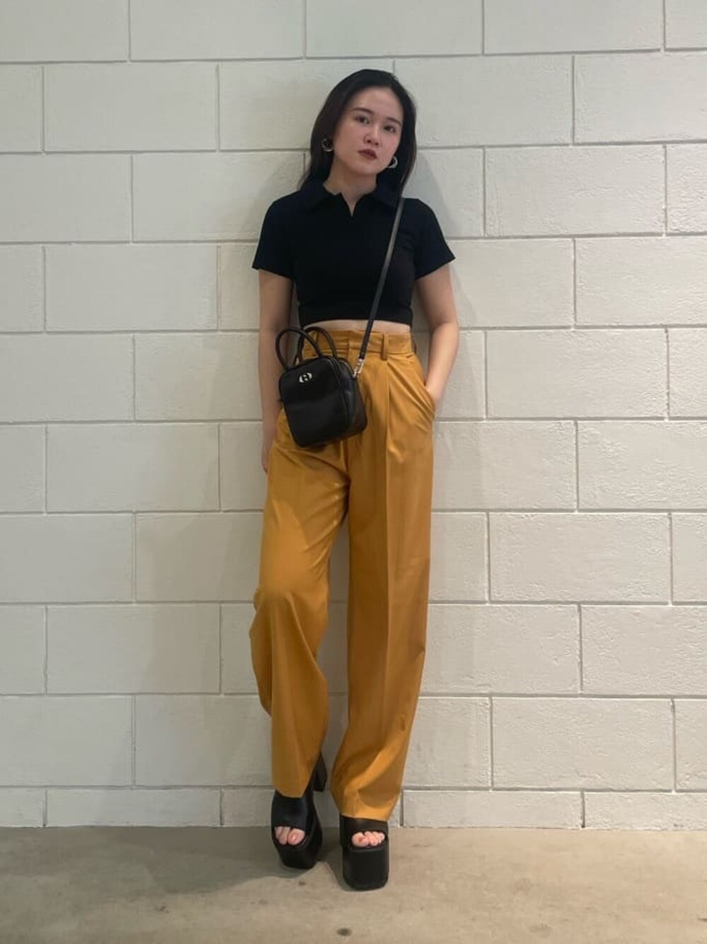 ブラック系のショルダーバッグ、オレンジ系のその他パンツ、ブラック系のサンダルを着用したレディースの夏コーディネートの1枚目の写真