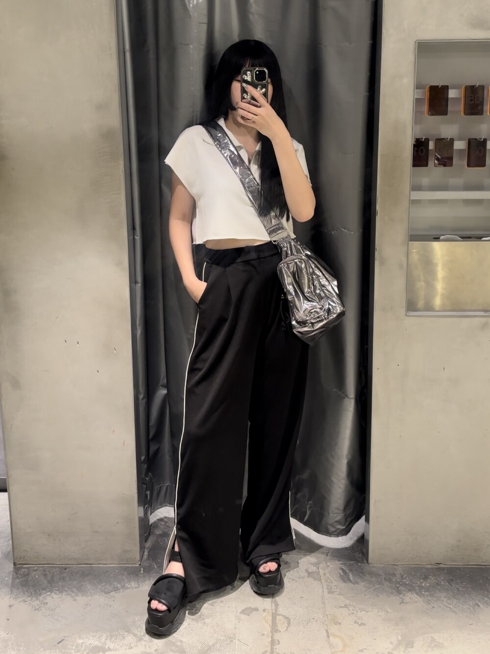 ブラック系のサンダル、ホワイト系のTシャツ/カットソー、ブラック系のスラックスを着用したレディースの夏コーディネートの1枚目の写真