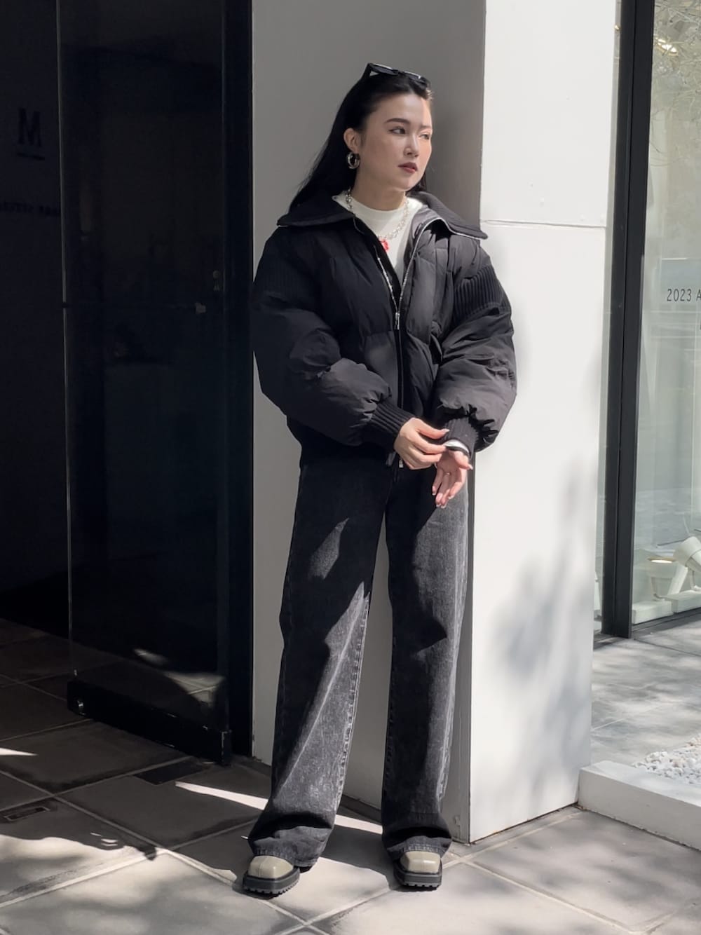 ブラック系のデニムパンツ、ブラック系のブーツ、ホワイト系のTシャツ/カットソーを着用したレディースの秋コーディネートの1枚目の写真