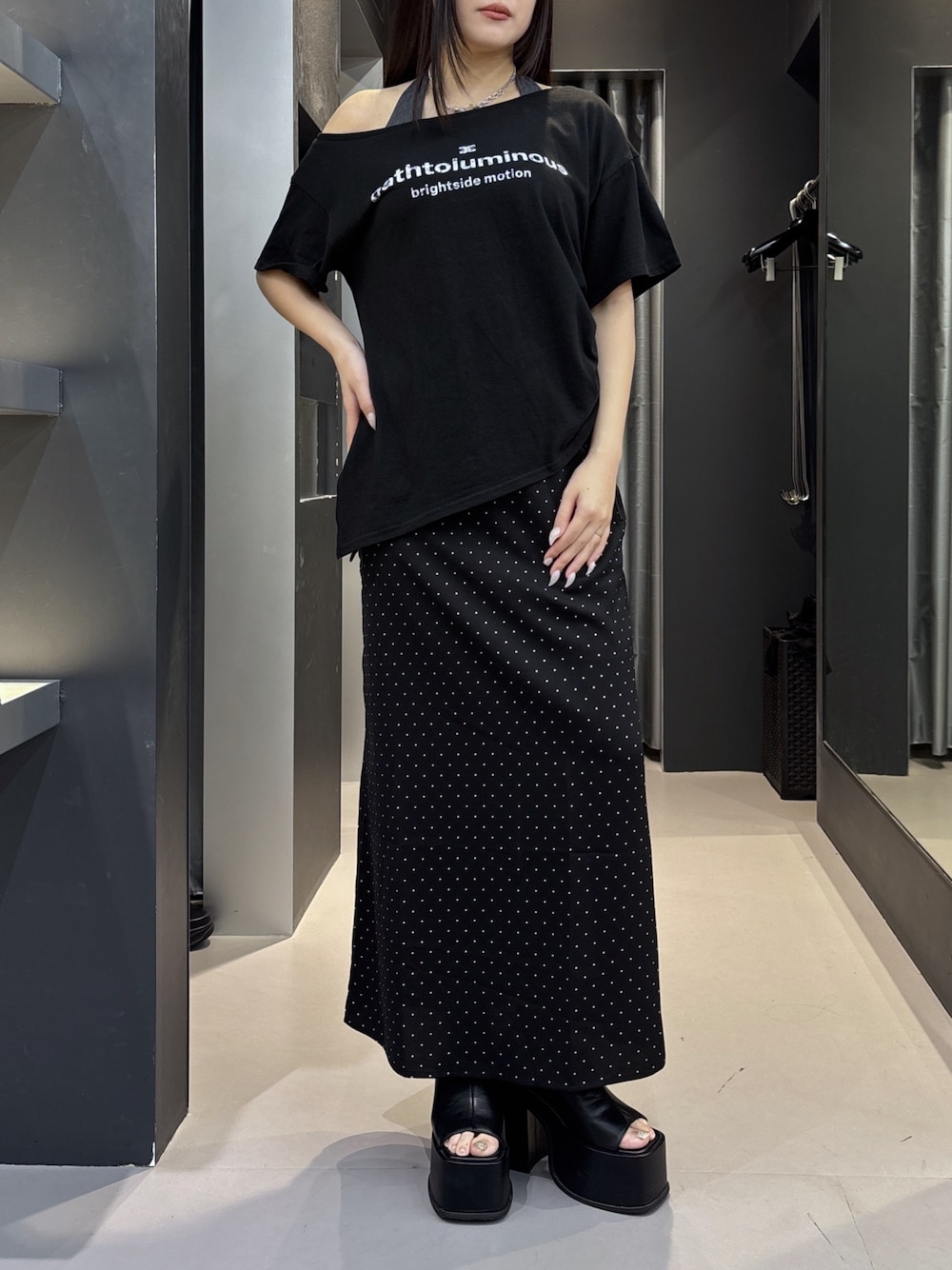 ブラック系のサンダル、ブラック系のスカート、ホワイト系のTシャツ/カットソーを着用したレディースの夏コーディネートの1枚目の写真