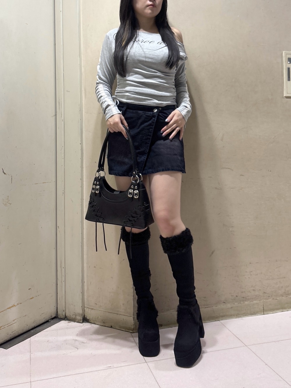 ブラック系のブーツ、ブラウン系のスカート、グレー系のTシャツ/カットソーを着用したレディースの秋コーディネートの1枚目の写真