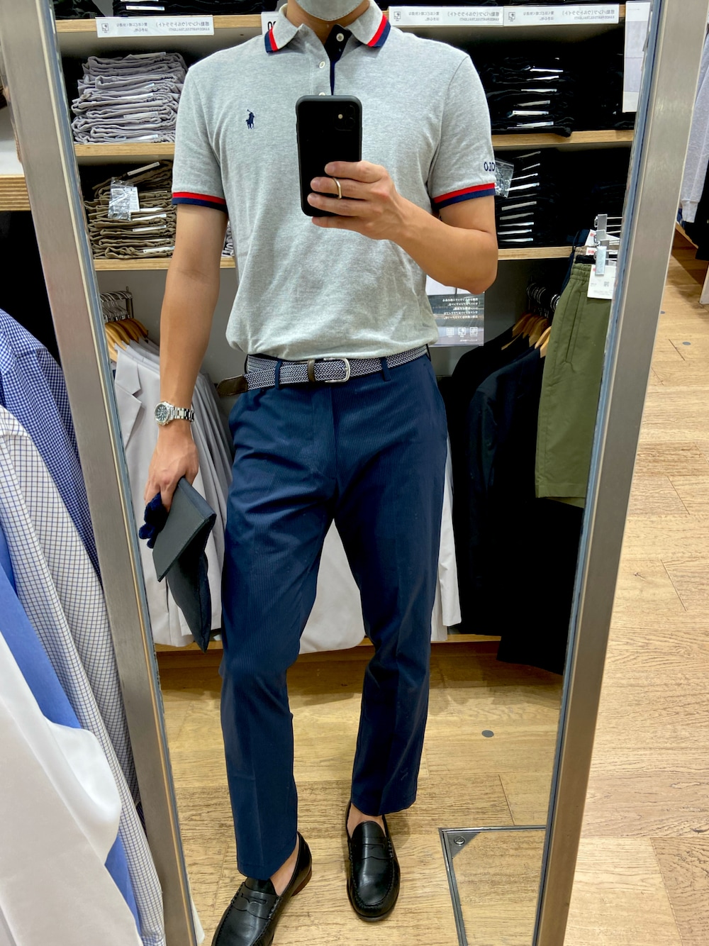 ブラック系のローファー、ブルー系のスラックス、グレー系のポロシャツを着用したメンズの夏コーディネートの1枚目の写真