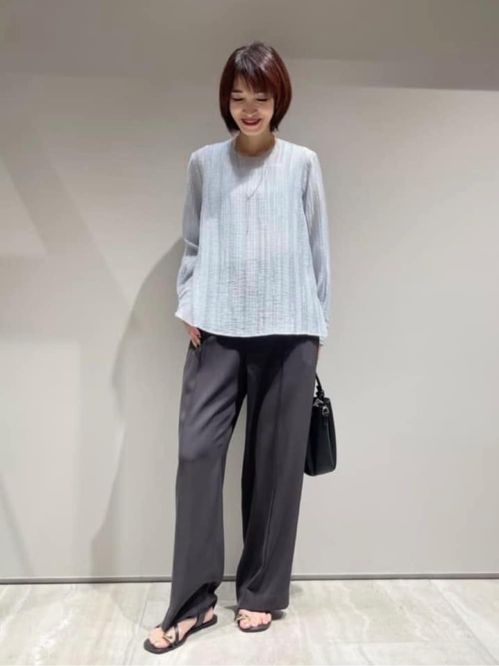 ブルー系のシャツ/ブラウス、グレー系のその他パンツ、シルバー系のネックレスを着用したレディースの春コーディネートの1枚目の写真