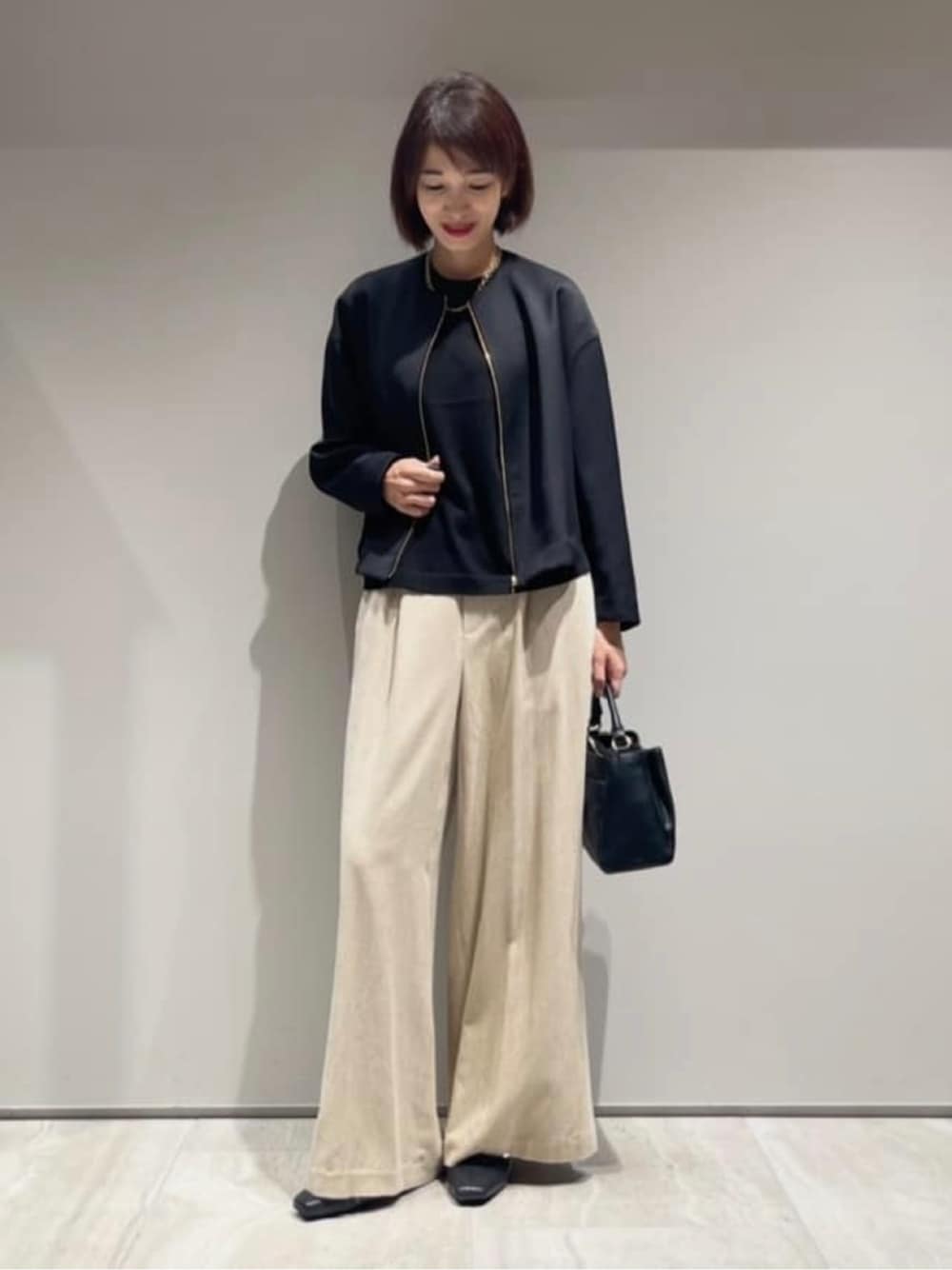 ベージュ系のその他パンツ、ブラック系のニット/セーター、ブラック系のブルゾンを着用したレディースの秋コーディネートの1枚目の写真