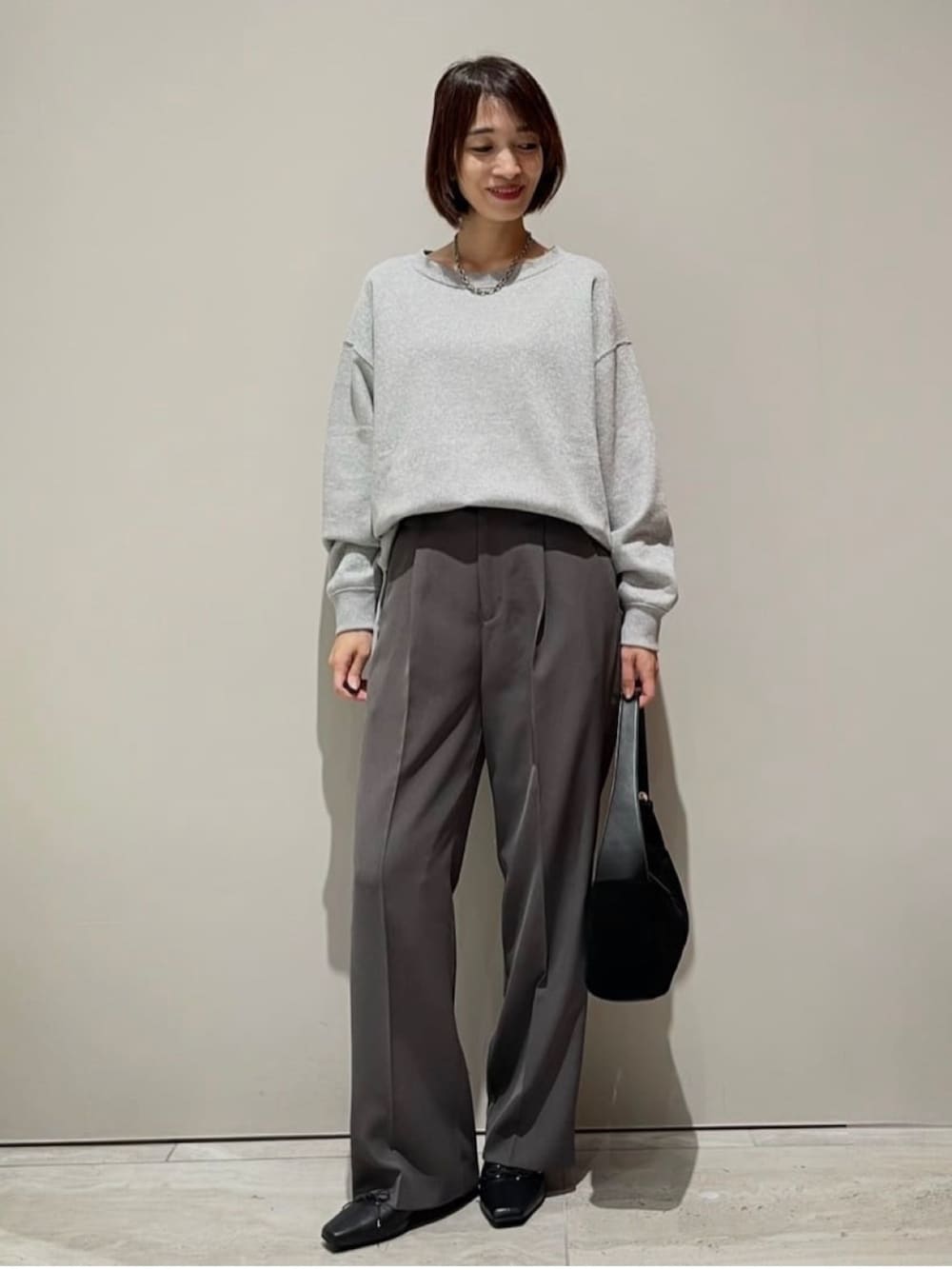 グレー系のその他パンツ、グレー系のTシャツ/カットソー、シルバー系のネックレスを着用したレディースの秋コーディネートの1枚目の写真