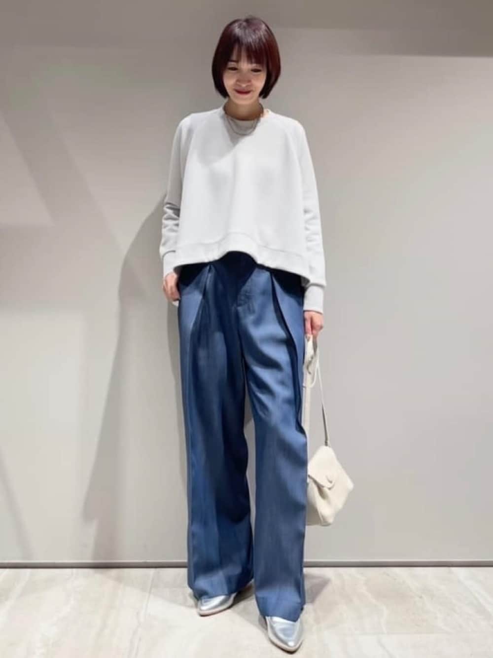 ホワイト系のショルダーバッグ、グレー系のスウェット、ブルー系のその他パンツを着用したレディースの冬コーディネートの1枚目の写真