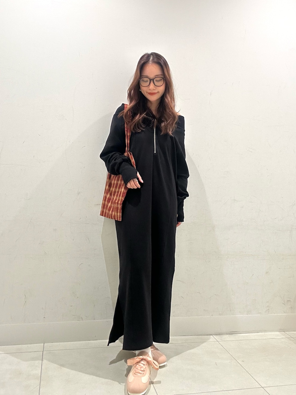 ブラック系のワンピース、レッド系のトートバッグ、ピンク系のスニーカーを着用したレディースの秋コーディネートの1枚目の写真