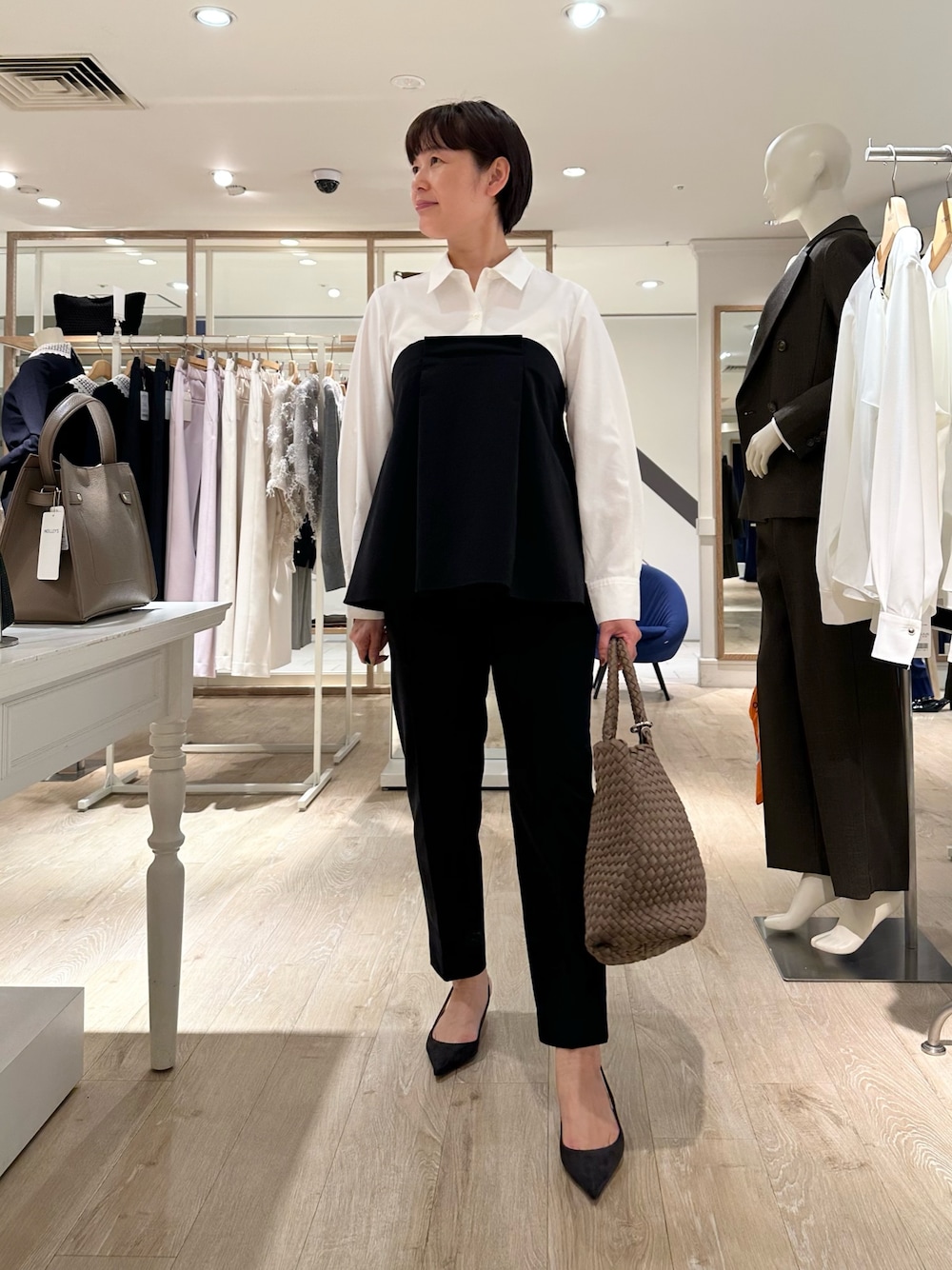 ブラック系のその他パンツ、ベージュ系のトートバッグ、ホワイト系のシャツ/ブラウスを着用したレディースの秋コーディネートの1枚目の写真