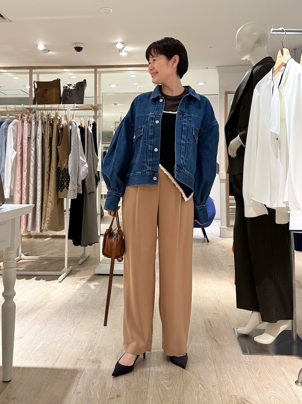 ブラック系のニット/セーター、イエロー系のショルダーバッグ、イエロー系のその他パンツを着用したレディースの秋コーディネートの1枚目の写真