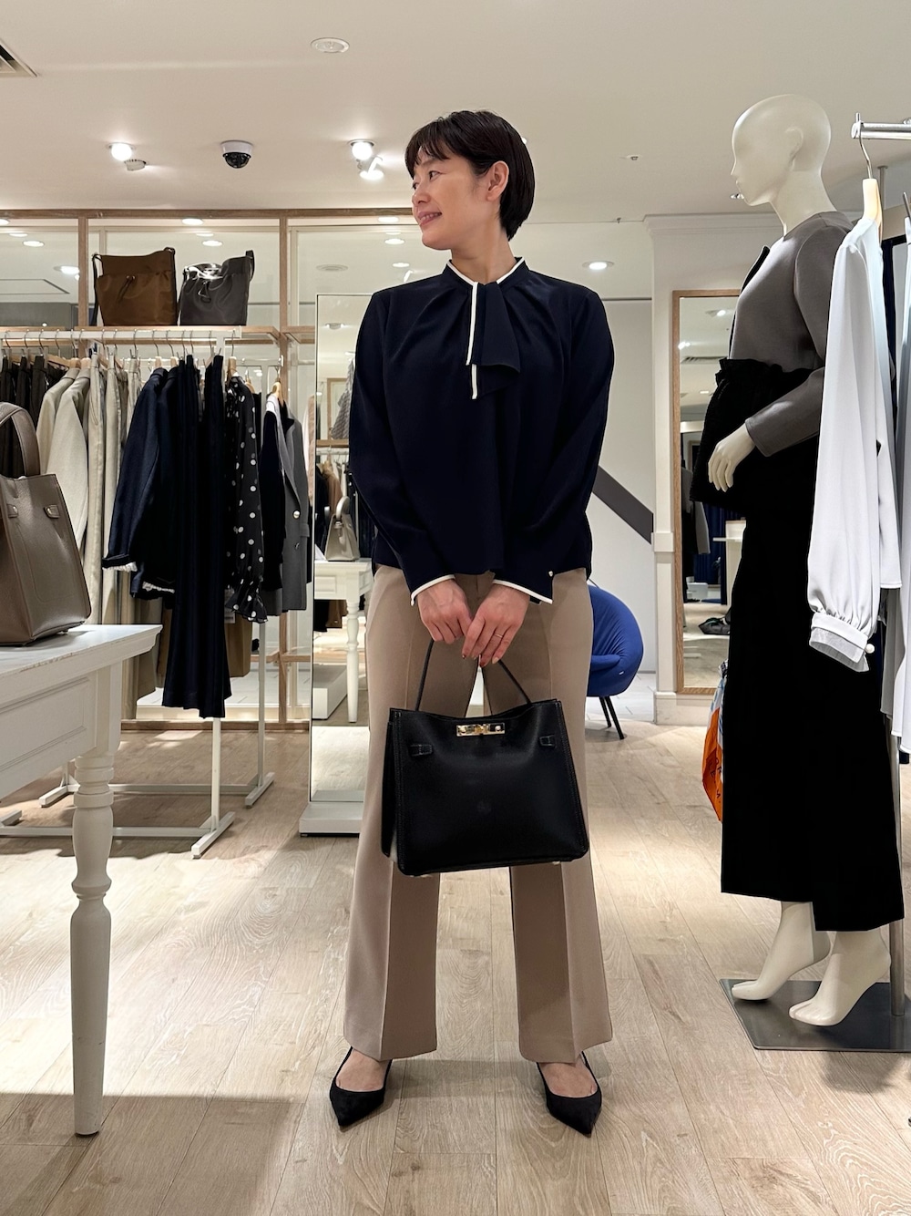 ベージュ系のその他パンツ、ブラック系のショルダーバッグ、ブルー系のシャツ/ブラウスを着用したレディースの秋コーディネートの1枚目の写真