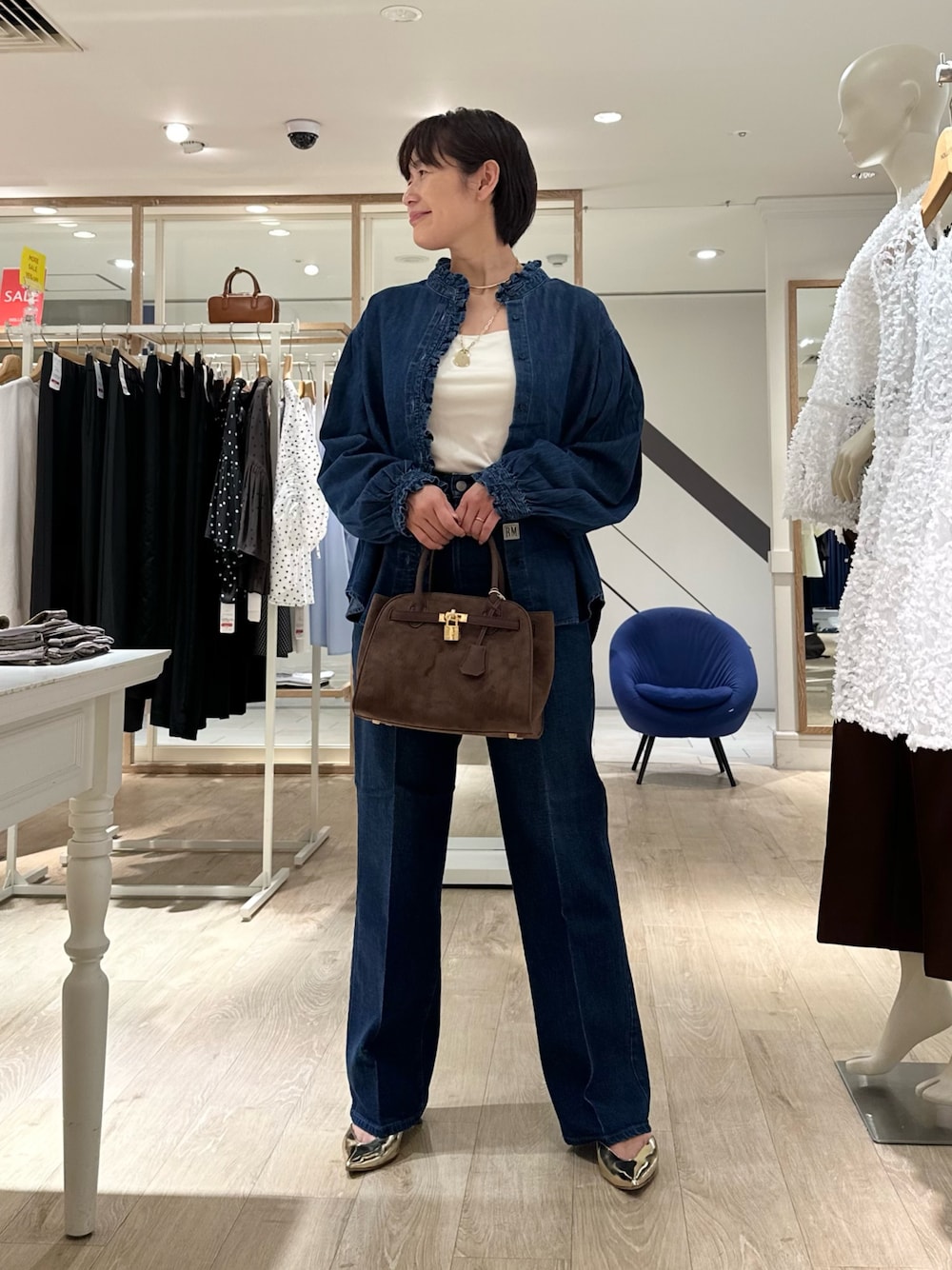 ブラウン系のトートバッグ、ブルー系のデニムパンツ、ブルー系のシャツ/ブラウスを着用したレディースの夏コーディネートの1枚目の写真