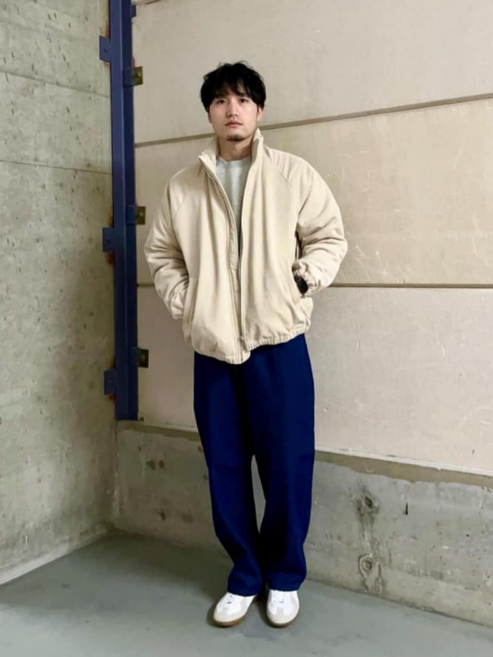 ホワイト系のスニーカー、ベージュ系のブルゾン、グレー系のスウェットを着用したメンズの冬コーディネートの1枚目の写真