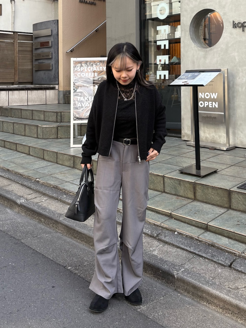 ブラック系のカーディガン/ボレロ、ブラック系のTシャツ/カットソー、ブラック系のバックパック/リュックを着用したレディースの春コーディネートの1枚目の写真