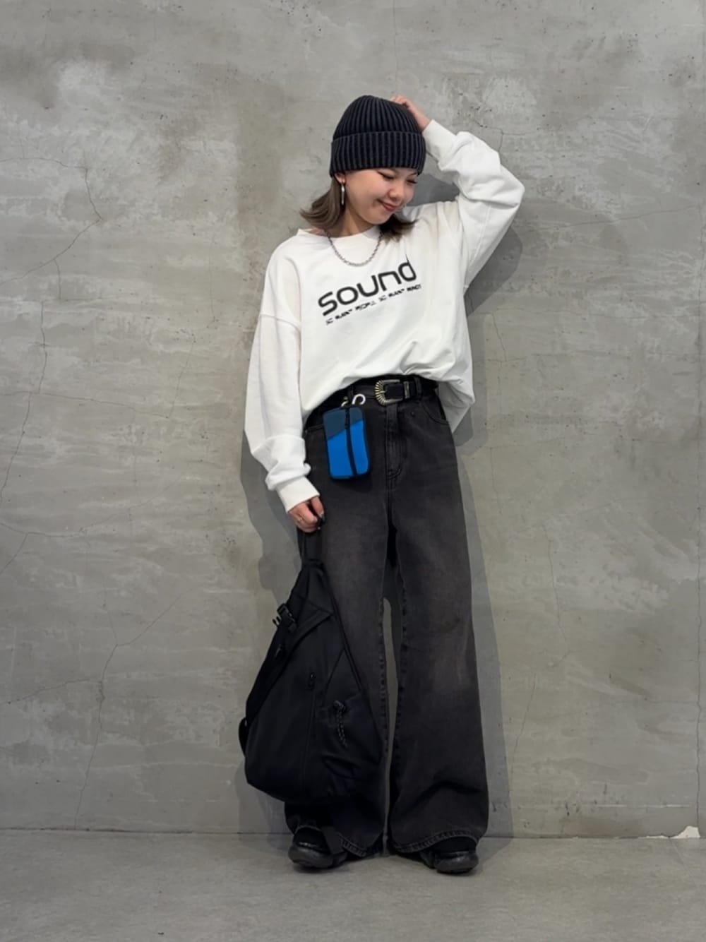 ブラック系のボディバッグ/ウエストポーチ、ブラック系のデニムパンツ、ホワイト系のTシャツ/カットソーを着用したレディースの秋コーディネートの1枚目の写真