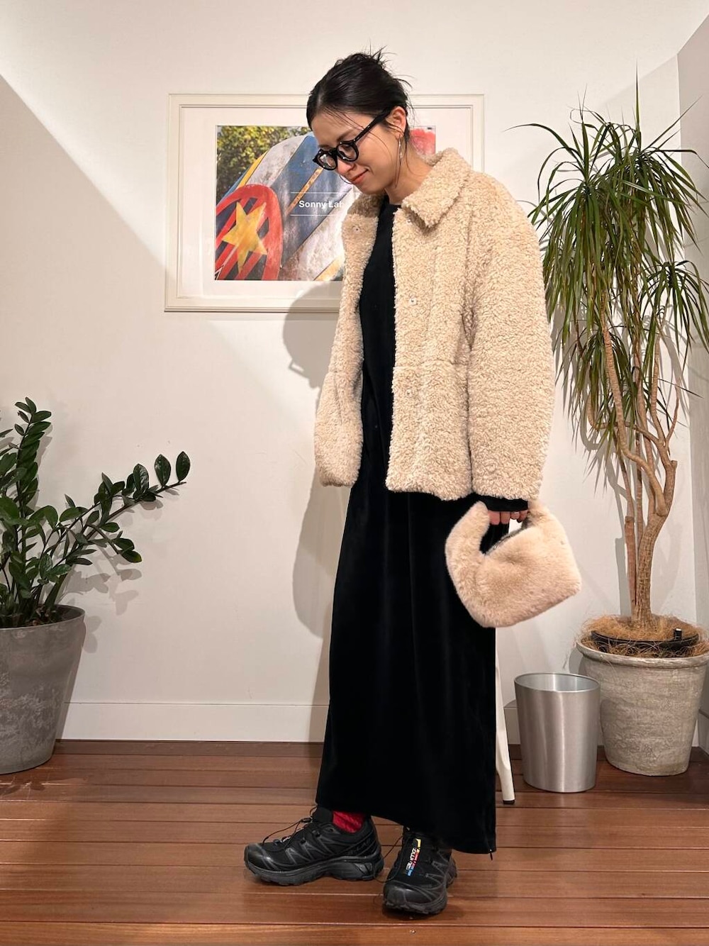 ホワイト系のブルゾン、ベージュ系のハンドバッグを着用したレディースの冬コーディネートの1枚目の写真