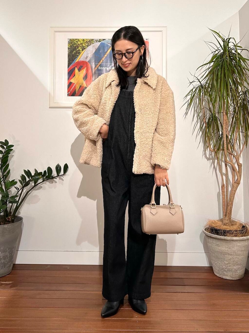 ブラック系のサロペット/オーバーオール、ホワイト系のブルゾン、ベージュ系のボストンバッグを着用したレディースの秋コーディネートの1枚目の写真