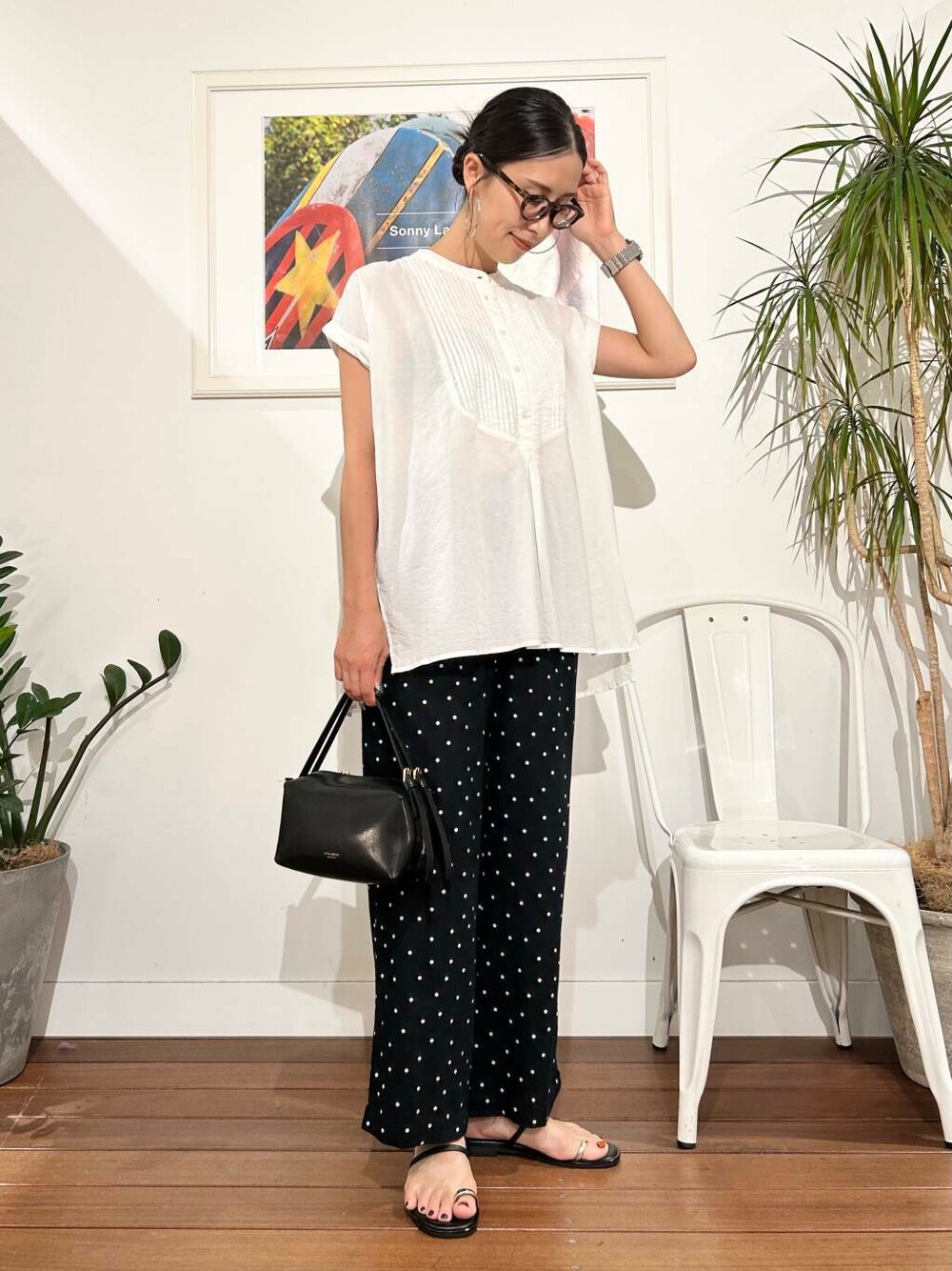 ブラック系のハンドバッグ、ブラック系のその他パンツ、ホワイト系のTシャツ/カットソーを着用したレディースの夏コーディネートの1枚目の写真