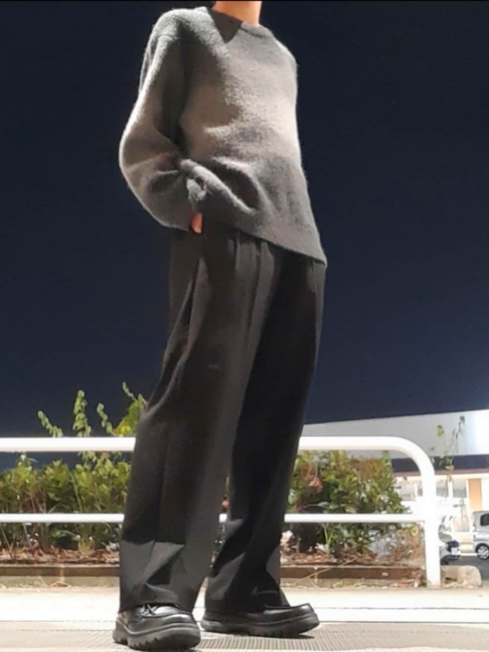 ブラック系のスラックス、グレー系のニット/セーターを着用したメンズの冬コーディネートの1枚目の写真