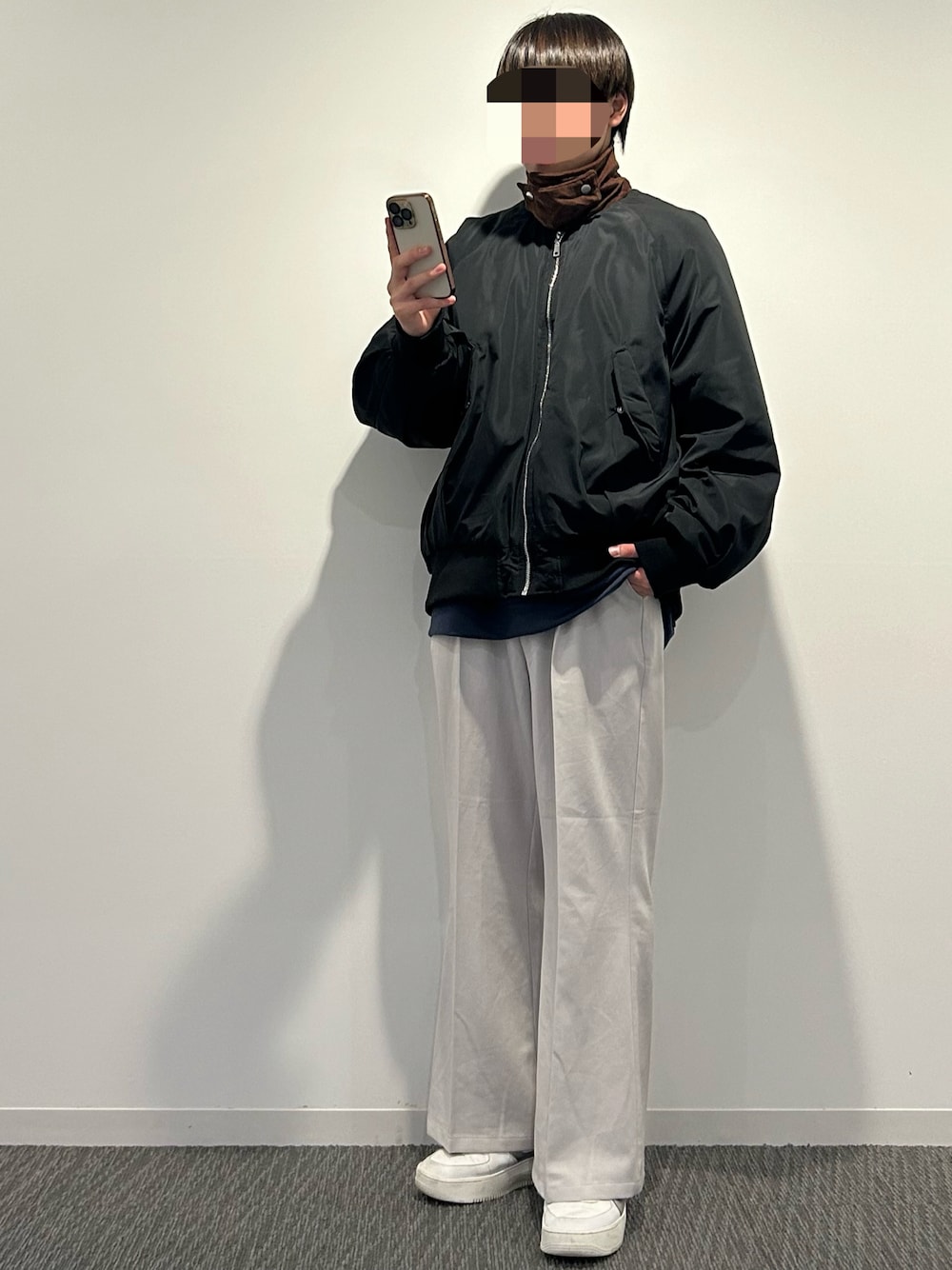 ブラック系のMA-1、グレー系のスラックス、ホワイト系のスニーカーを着用したメンズの秋コーディネートの1枚目の写真